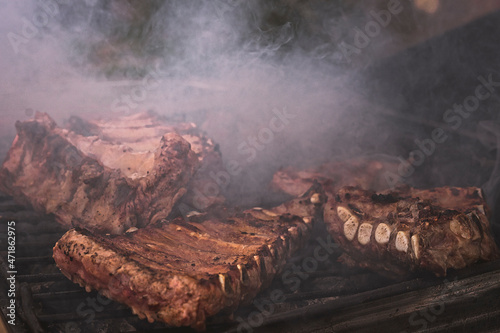 Costillas de cerdo ibérico haciéndose a la brasa en la parrilla al aire libre en el campo. photo