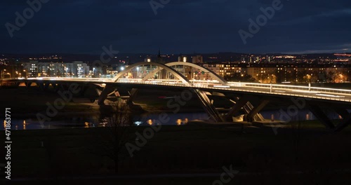 Dresden Elbe bridge in the evening. Time lapse video of fast moving cars on a street. The building is illuminated at night. The Waldschlösschen bridge exterior is a famous landmark in the city. photo