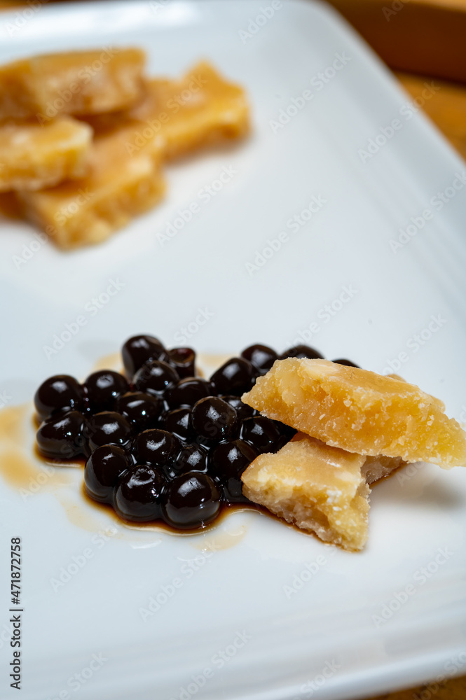 Tasting of very old Italian parmigiano-reggiano parmesan cheese from Parma with extremely grainy and crumbly structure and very intense taste with black pearls of balsamic vinegar DOP from Modena. Tasting of very old Italian parmigiano-reggiano parmesan cheese from Parma with extremely grainy and crumbly structure and very intense taste with black pearls of balsamic vinegar DOP from Modena.