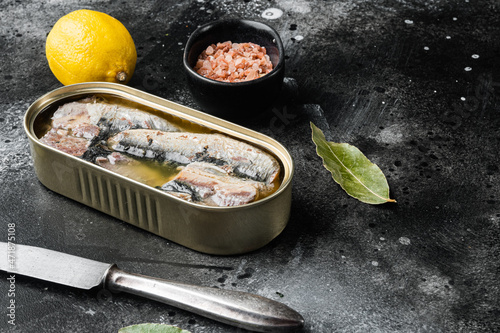 Sardines can preserve, on black dark stone table background, with copy space for text photo