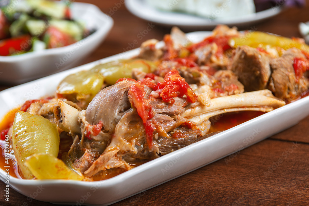 Khashlama is popular Armenian dish, which is prepared from beef with vegetables. Khashlama in the plate. stewed lamb on the bone with vegetables on wooden desk Khashlama is popular Armenian dish, which is prepared from beef with vegetables. Khashlama in the plate. stewed lamb on the bone with vegetables on wooden desk