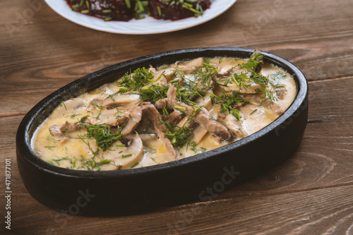 a dish made of pieces of beef, mushroom in cream sauce on dark wood