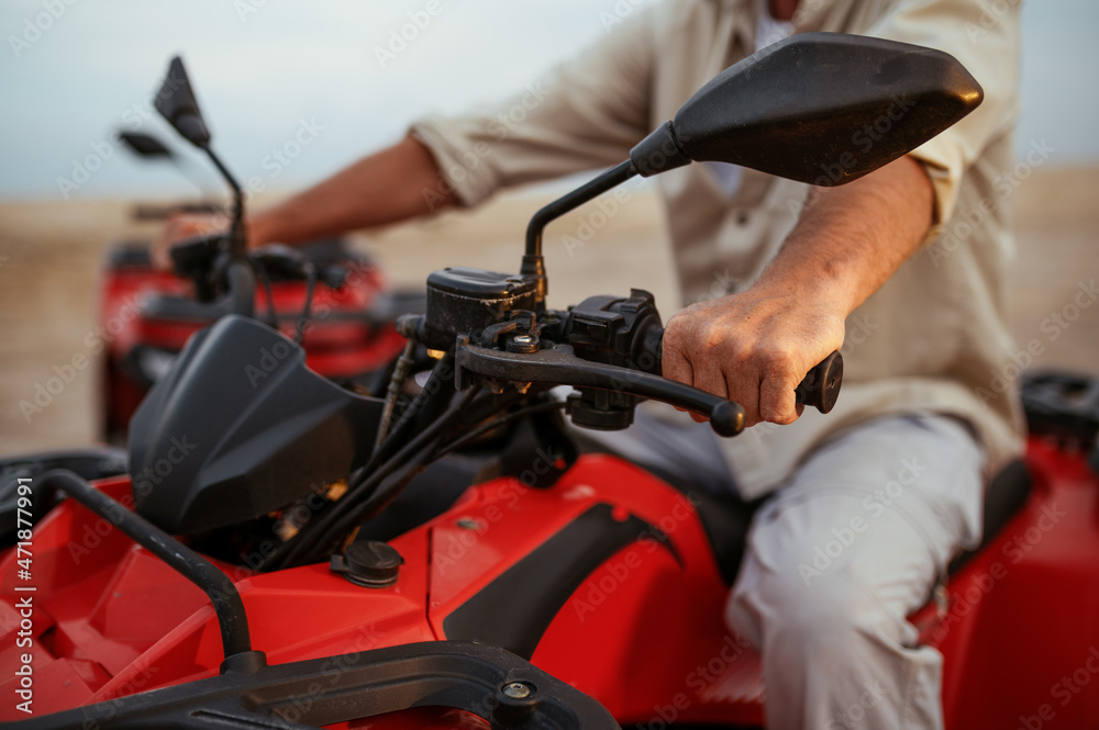 Atv racer in desert, closeup front view on hands Atv racer in desert, closeup front view on hands
