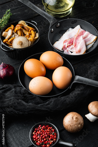 Breakfast egg ingredients, on black wooden table background