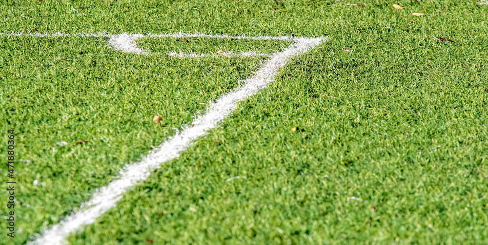 Green artificial football background close-up.