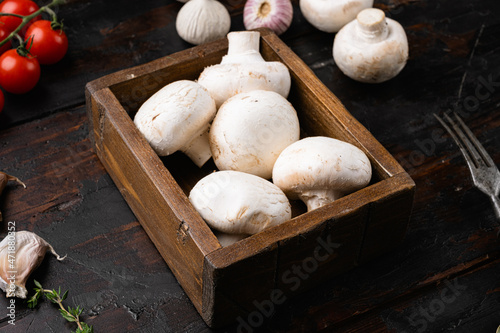 Raw mini mushroom champignon, on old dark wooden table background