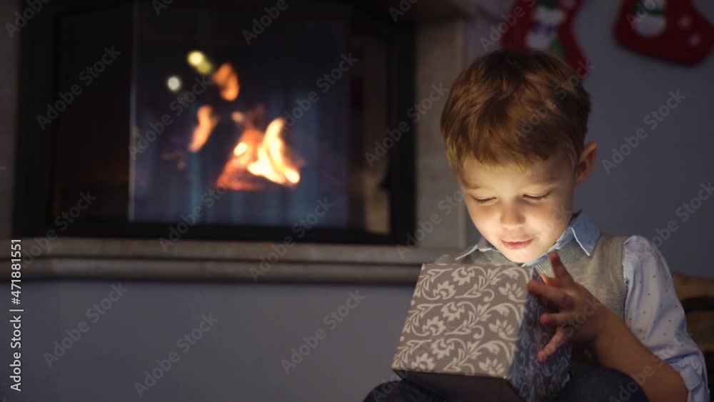 young boy kid looking at a Christmas present