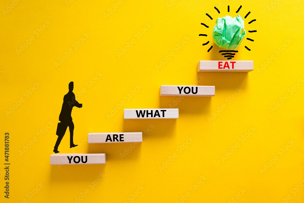 You are what you eat symbol. Wooden blocks with words 'You are what you eat'. Beautiful yellow background, copy space. Doctor icon, light bulb. Healthy eating concept. Copy space.