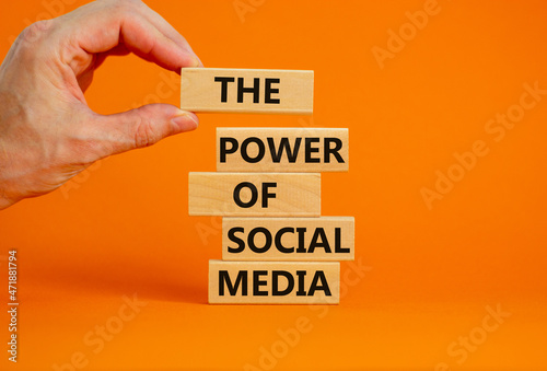 Power of social media symbol. Wooden blocks with words The power of social media. Businessman hand. Beautiful orange background, copy space. Business, power of social media concept.
