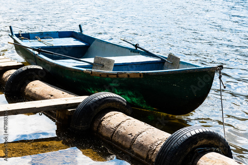 Boat moored to the shore. Belis Fantanele lake, Apuseni mountains, Romania. photo