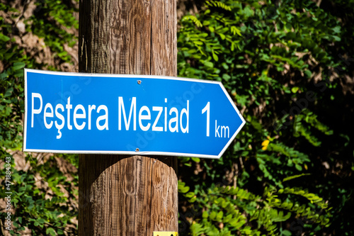 Signpost with the direction to Meziad cave. Route marking for tourists. Bihor, Romania.