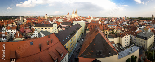 Old houses with red roofs with St. Peter Dom (Regensburg Cathedral) in Regensburg, Germany . Seen from a tower of Dreieinigkeitskirche church during summer sunny day with clouds.