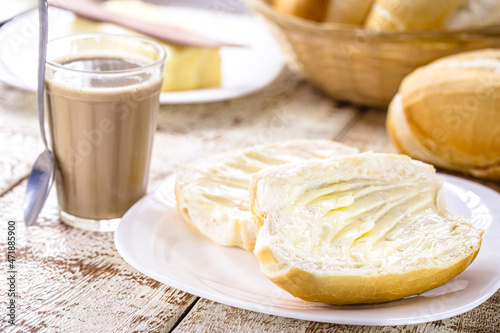 Brazilian breakfast, French bread with butter and coffee with milk photo
