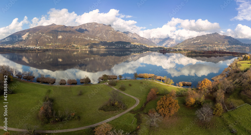  Aerial view of an alpine lake and the surrounding mountains and vegetations reflected