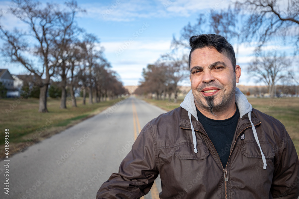 Handsome happy man standing in an empty street wearing a cool brown jacket and camo pants. Handsome happy man standing in an empty street wearing a cool brown jacket and camo pants.