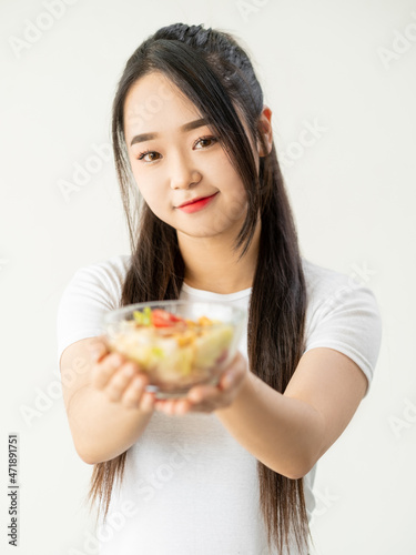 Vegetarian diet. Healthy food. Fresh meal. Natural nutrition. Cheerful woman holding bowl of salad lunch isolated on white background.