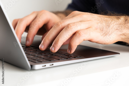Mans hands on a computer keyboard typing a text. Homeoffce or freelancer working at home.