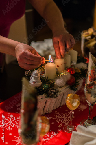 detail of a woman lighting an advent candle