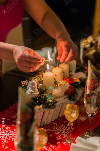 detail of a woman lighting an advent candle