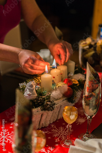detail of a woman lighting an advent candle