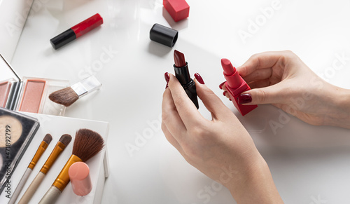 Obraz na plátně woman chooses red lipstick to match the color of nail polish