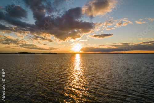 Sunset over the lake. Blue sky and orange sun during summer sundown. 