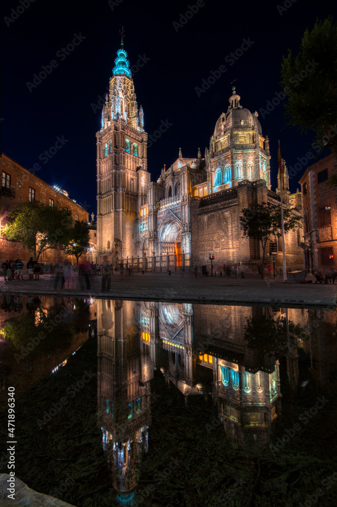 Night view of the cathedral of Toledo reflected in a fountain, Spain.