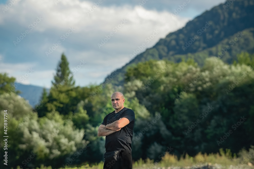 Male traveler against the background of mountains in the warm season. Merging with nature, beauty of landscapes Male traveler against the background of mountains in the warm season. Merging with nature, beauty of landscapes