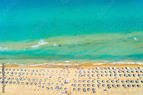 Платно Top view aerial drone photo of Banana beach with beautiful turquoise water, sea waves and straw umbrellas