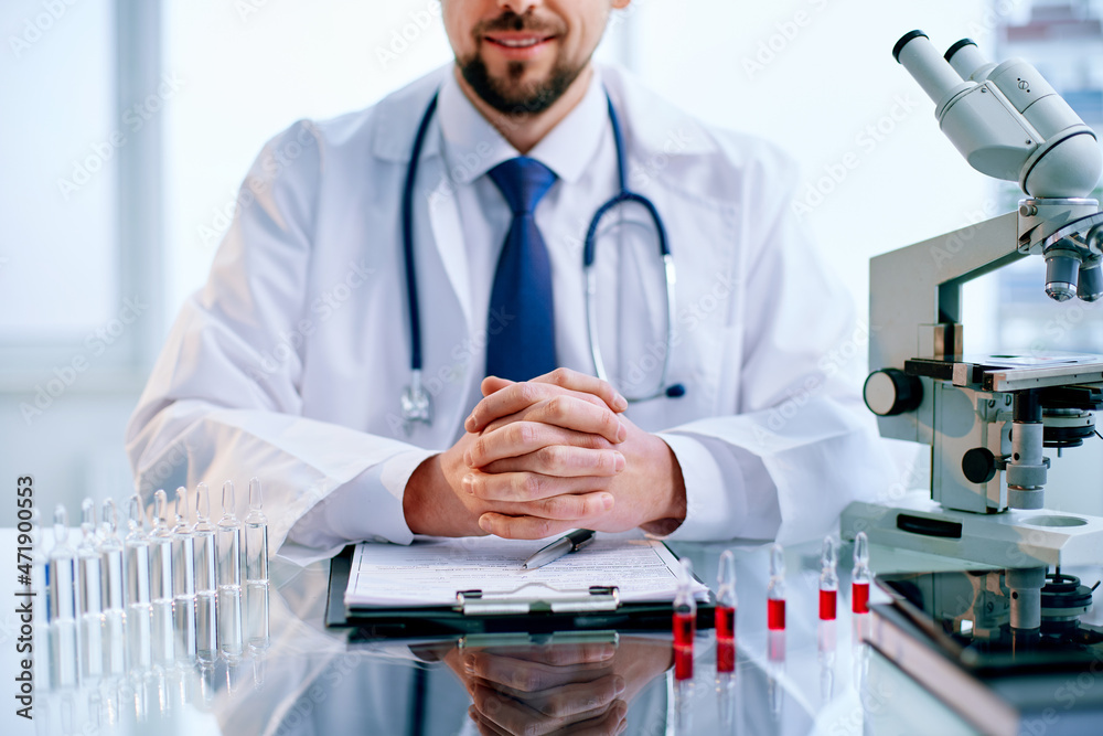 scientist sitting at a desk in a science lab. scientist sitting at a desk in a science lab.