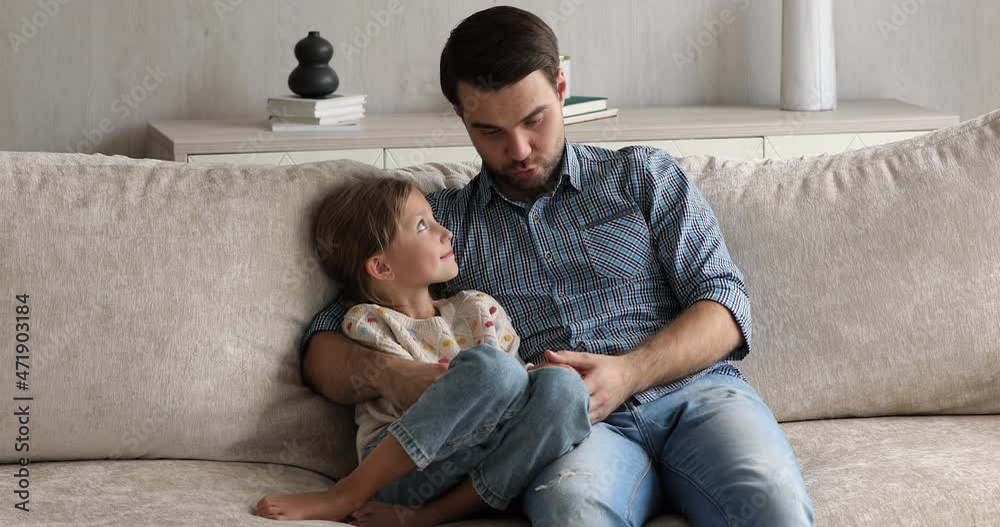 Loving young single dad embrace with warmth little preteen daughter kid hold sincere conversation discuss affairs answer child question. Friendly millennial father talk to school age girl on cozy sofa vídeo de Stock | Adobe Stock