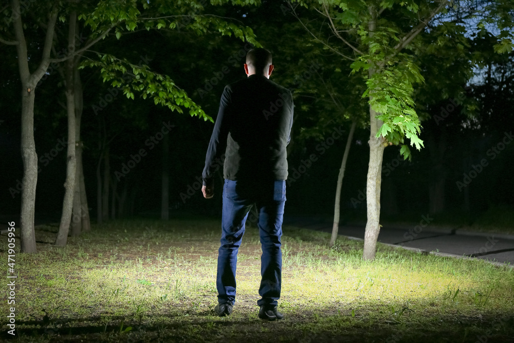 Fototapeta premium Mature man with flashlight at night