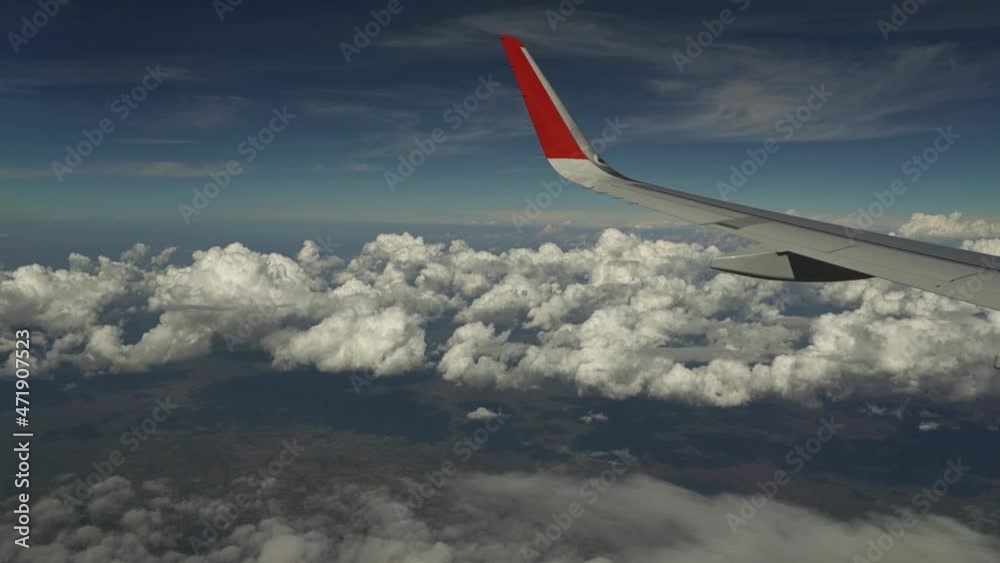 Wing of plane flies above clouds. View from eluminator. Clouds fly by below. Clouds quickly sweep under the wing. Wing of plane flies above clouds. View from eluminator. Clouds fly by below. Clouds quickly sweep under the wing.