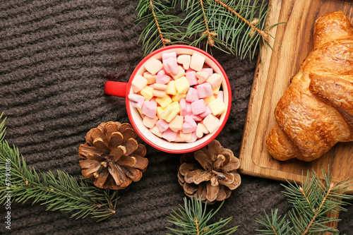 Fototapeta Naklejka Na Ścianę i Meble -  Cup of cocoa with marshmallows, fir cones, branches and croissant on warm scarf