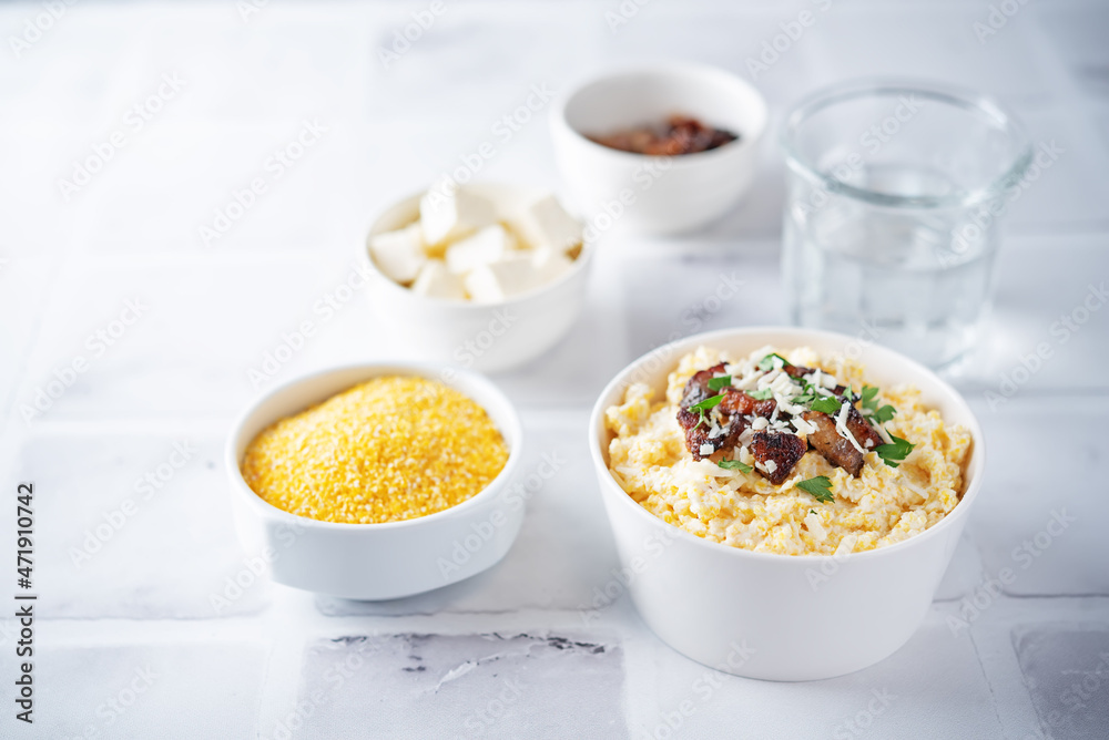 Corn porridge with fried bacon, parsley and Feta cheese in a bowl Corn porridge with fried bacon, parsley and Feta cheese in a bowl