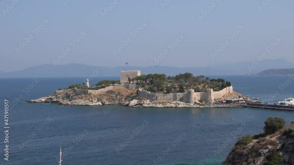 Kusadasi, Turkey - August 23, 2021: Pigeon Island Castle, (Guvercinada kalesi in Turkish) is a tourist attraction. Kusadasi, Turkey - August 23, 2021: Pigeon Island Castle, (Guvercinada kalesi in Turkish) is a tourist attraction.