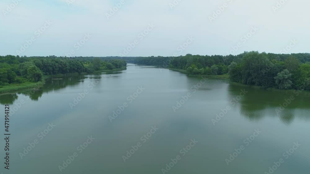 Aerial view beautiful nature forest and lake in which fisherman is fishing sitting on an inflatable boat in the middle of the lake. Drone wide shot adult man in the middle of a pond Aerial view beautiful nature forest and lake in which fisherman is fishing sitting on an inflatable boat in the middle of the lake. Drone wide shot adult man in the middle of a pond