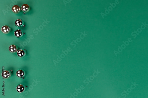 Merry Christmas or Happy New Year holiday theme. Shiny decorations on a green background in flat lay format
