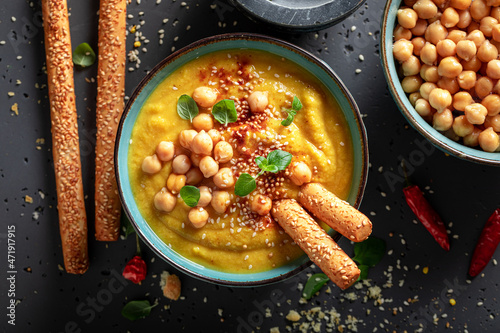 Healthy chickpea soup with grissini and sesame seeds.