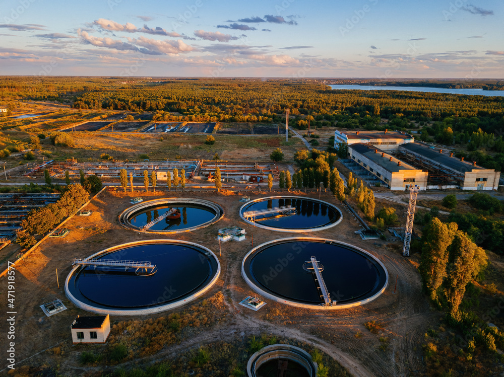Modern sewage treatment plant. Round wastewater purification tanks at sunset, aerial view - obrazy, fototapety, plakaty 