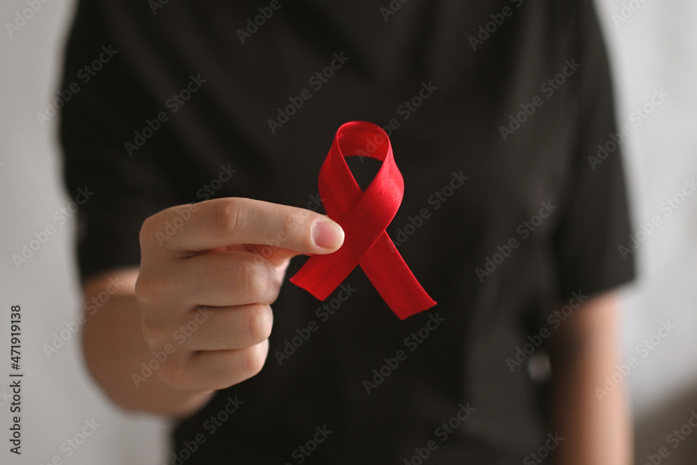 World AIDS and hiv day. Woman in black T-shirt holds a red ribbon. Blood transfusion and donation. Hemophilia day. World Cancer Day World AIDS and hiv day. Woman in black T-shirt holds a red ribbon. Blood transfusion and donation. Hemophilia day. World Cancer Day