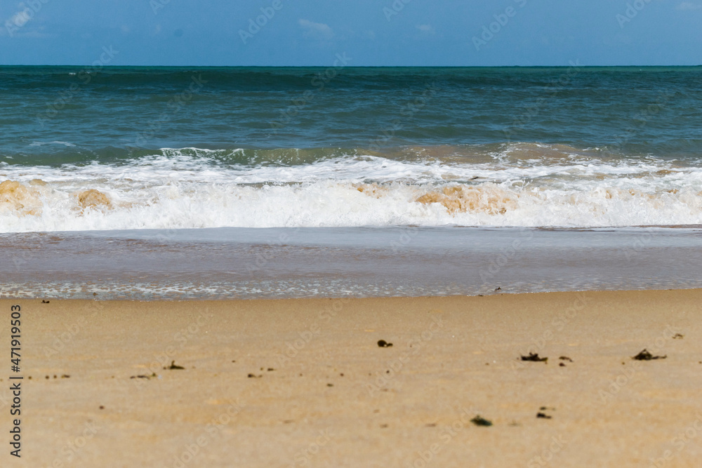 linda praia com areias escuras, ondas e céu azul linda praia com areias escuras, ondas e céu azul