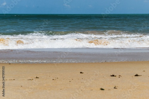 linda praia com areias escuras, ondas e céu azul © Diovane