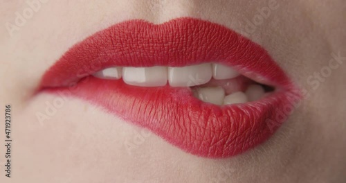 Teeth Bitting Red Lips a Macro Shot of Female Mouth
