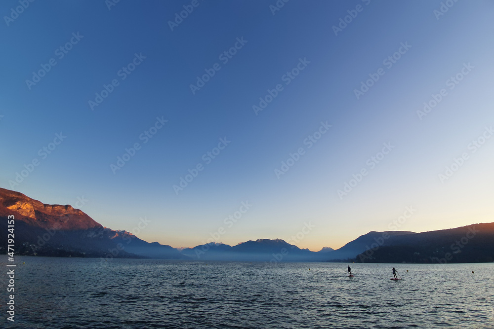 Two paddlers in Annecy lake at sunset