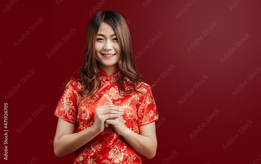 Beauty Asian woman in red chinese dress and smiling to you in chinese new year, on red background Beauty Asian woman in red chinese dress and smiling to you in chinese new year, on red background