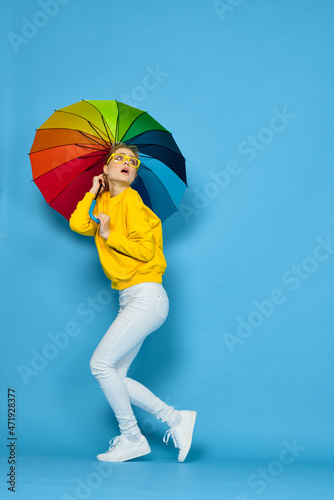 woman with multicolored umbrella in yellow sweater posing rainbow colors