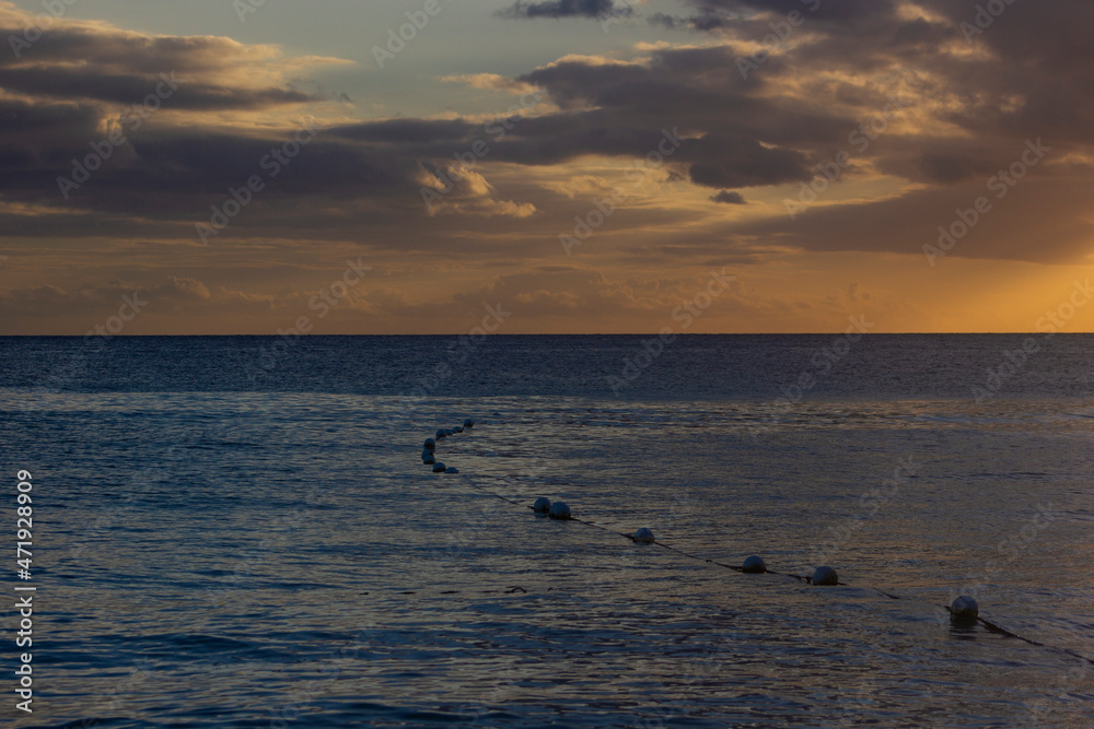 SUNSET ON THE BEACH WITH ORANGE LIGHT AND BLUE SKY WITH SOME CLOUDS SUNSET ON THE BEACH WITH ORANGE LIGHT AND BLUE SKY WITH SOME CLOUDS