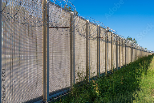 selective focus on international border fence with razor wire at the topin the United States