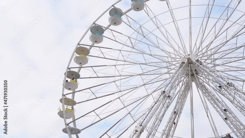 Rotating Giant Ferris Wheel at daytime with cloudy sky background - Static shot
Rotating Giant Ferris Wheel at daytime with cloudy sky background - Static shot